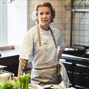 Chef Dinise Simpon wearing an apron while standing in a kitchen