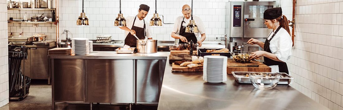 Three chefs working in a clean and organized kitchen