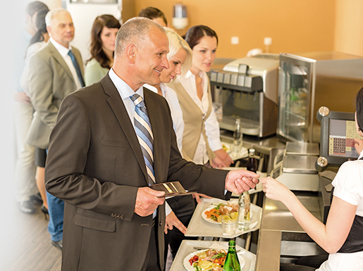 Man in business suit paying for tray of food in checkout line